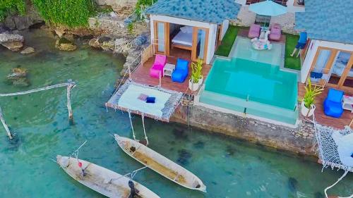 uma vista aérea de uma casa com dois barcos na água em Indigo Blue Ceningan em Nusa Lembongan