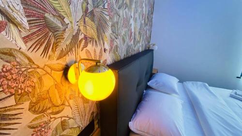 een slaapkamer met een gele lamp naast een bed bij BED Cauchy in Namen