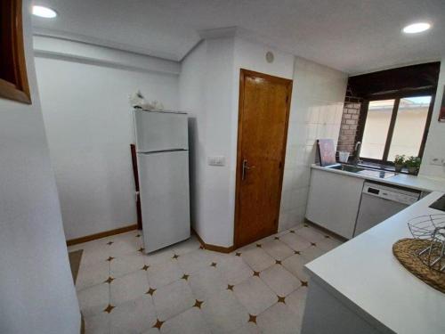 a kitchen with a white refrigerator and a sink at Bonito apartamento en Laredo in Laredo