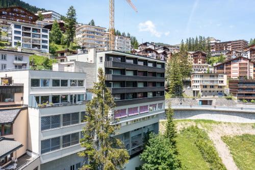 Cristallo Arosa Hotel في أروسا: عمارة سكنية في مدينة بها أشجار