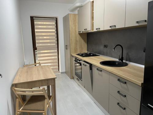 cocina con encimera, fregadero y fogones en Apartament Moghioros Park Residence DUM1, en Bucarest