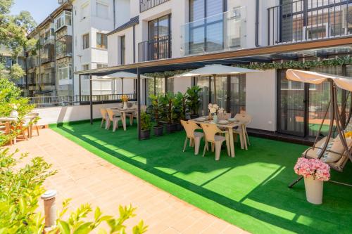 an outdoor patio with tables and chairs on green grass at Sevastopol apartments Varna in Varna City