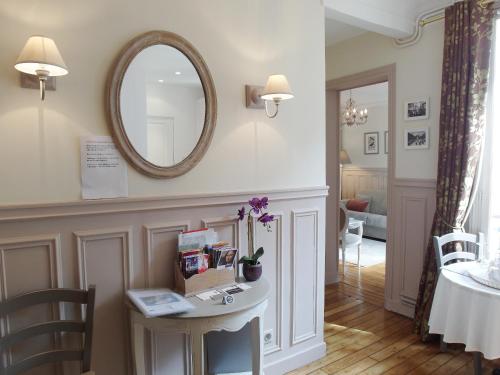 a living room with a table and a mirror at Chambre d hôte : Louvre Elegant Apt Suite in Paris