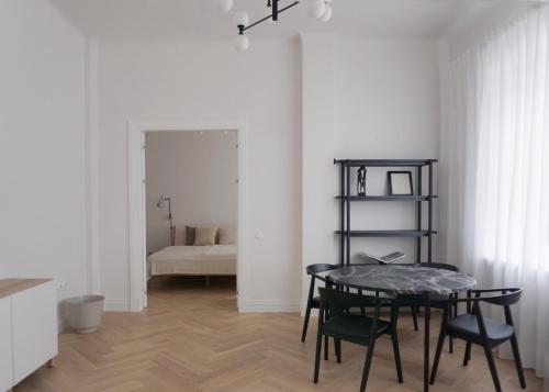 jadalnia ze stołem i krzesłami oraz sypialnia w obiekcie Apartament No.4 w mieście Windawa