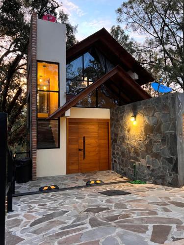 Casa con puerta de madera y pared de piedra en Cabañas San Marcos, en Mazamitla