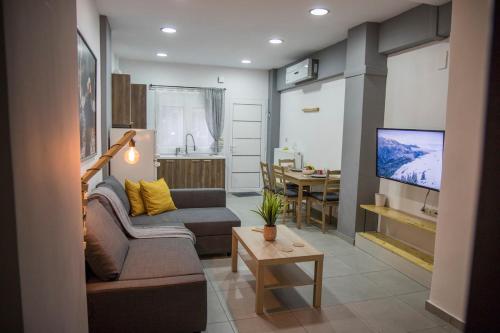 a living room with a couch and a tv and a table at BILLYS HOUSE in Tríkala