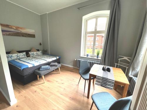 um pequeno quarto com uma cama, uma mesa e cadeiras em Gästehaus Sternschanze - App2 Kapitänleutnant em Stralsund