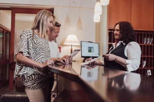 een groep mensen die rond een bureau staan bij Hotel Summerhof in Bad Griesbach