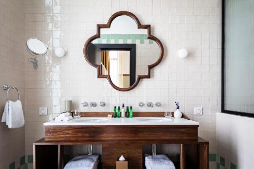 a bathroom with a sink and a mirror at La Maison Palmier Abidjan, a Member of Design Hotels in Abidjan