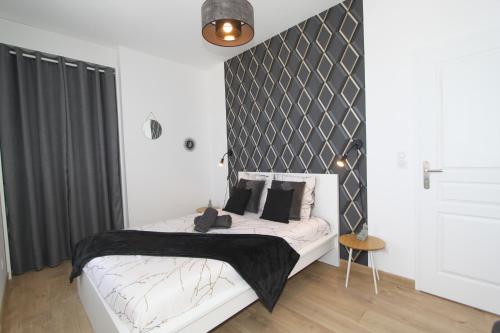 een slaapkamer met een bed met een zwart-wit hoofdeinde bij L'Urbain by EasyEscale in Romilly-sur-Seine