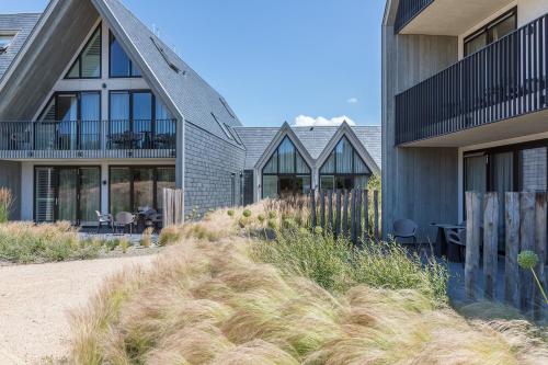 een huis met hoog gras ervoor bij Hotel Zeeuws Licht I Kloeg Collection in Dishoek