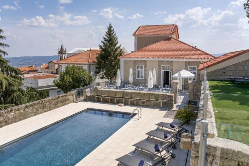 eine Villa mit einem Pool und einem Haus in der Unterkunft Casa das Muralhas in Covilhã