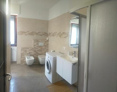 bagno con lavatrice e lavandino di Casa BRUMANA a Tirano