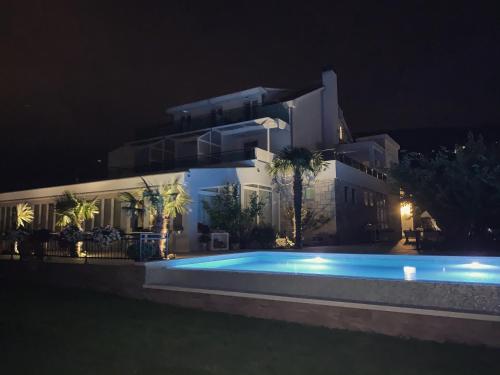 - une piscine en face d'un bâtiment la nuit dans l'établissement Villa Pitomcia, à Podstrana