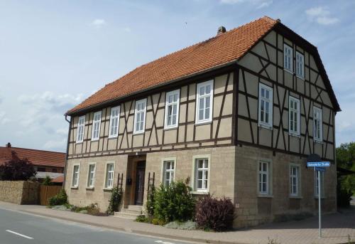 un bâtiment avec un toit marron et des fenêtres blanches dans l'établissement FeWo Gutendorf, à Bad Berka