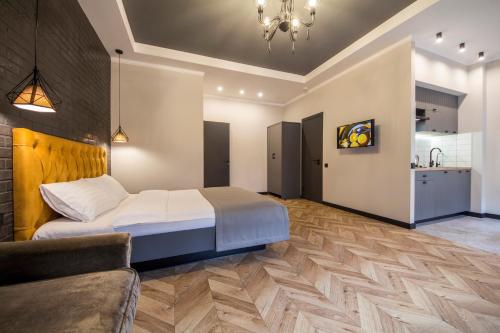 Cet appartement comprend une chambre avec un lit et un canapé ainsi qu'une cuisine. dans l'établissement Idea Design Apart-Hotel Prorizna, à Kiev