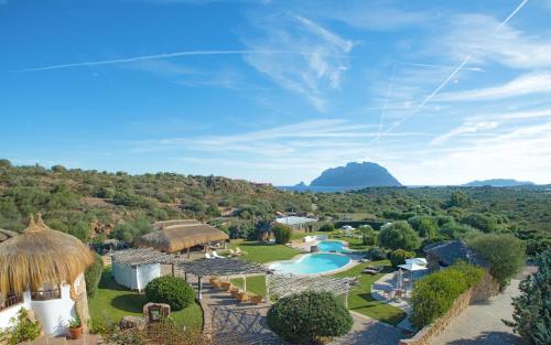 uma vista aérea de um resort com uma piscina em Hotel Ollastu em Costa Corallina