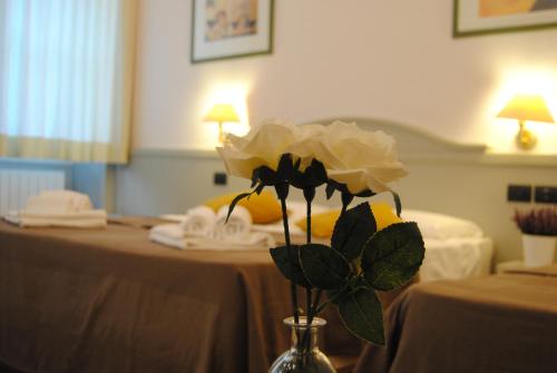 un jarrón con una flor en una mesa en Hotel Camilla Firenze, en Florencia