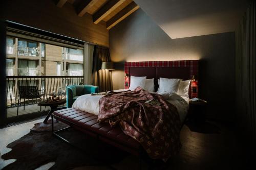 um quarto com uma cama e uma grande janela em Bergwelt Grindelwald - Alpine Design Resort em Grindelwald