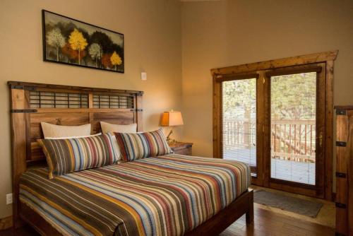 een slaapkamer met een bed met een gestreept dekbed bij Spacious 2nd story loft with awesome views in Estes Park