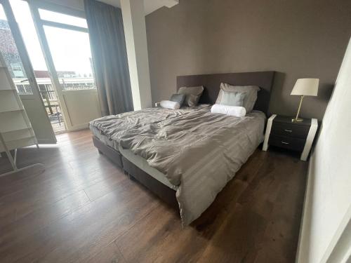 um quarto com uma cama grande e piso em madeira em TopSleep Apartments 26-1 em Arnhem