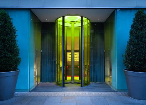 uma entrada para um edifício com uma porta giratória amarela em St Martins Lane London em Londres