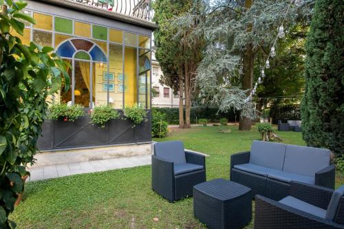 een patio met 2 stoelen en een tafel bij Villa Romantica Wellness & SPA in Lucca