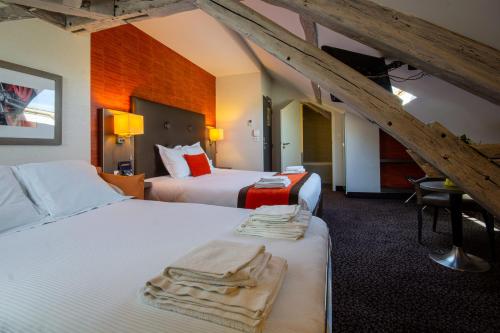 um quarto de hotel com duas camas com toalhas em Hotel de la Gare Troyes Centre em Troyes