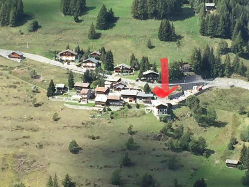 un avión rojo está volando sobre una casa en Affittacamere Buenavista Guest House, en Champoluc