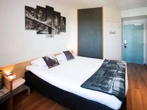 A bed or beds in a room at ibis Fribourg