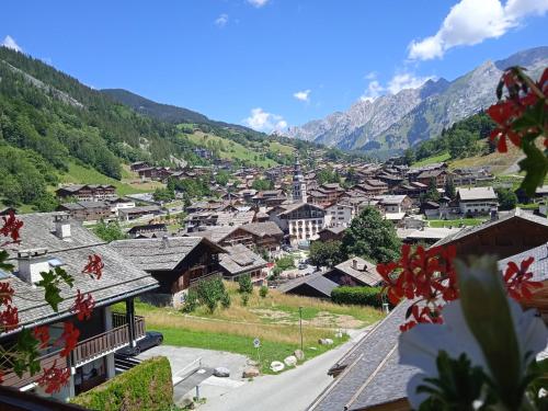 a view of a village with mountains in the background at Hotel les Sapins in La Clusaz