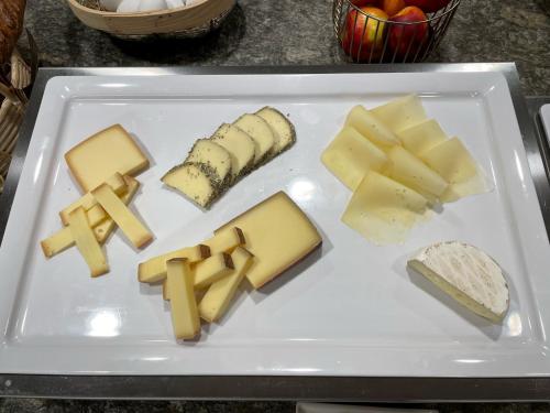 um prato de queijo e outros alimentos sobre uma mesa em Boutique Hotel La Gorge em Saas-Fee