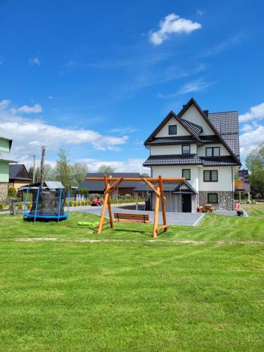 un parco con panchina di fronte a una casa di Domki i Apartamenty Krupa Ciche a Zakopane