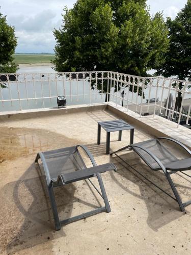 una panchina, un tavolo e una sedia di Logis Hôtel- Restaurant Le Relais Guillaume de Normandy a Saint-Valéry-sur-Somme