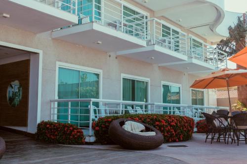 een gebouw met een patio met stoelen en een parasol bij Hotel Paradiso del Sol in Cabo Frio