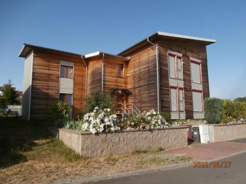 ein Holzhaus mit Blumen davor in der Unterkunft Apartmán v dřevěném domě in Franzensbad