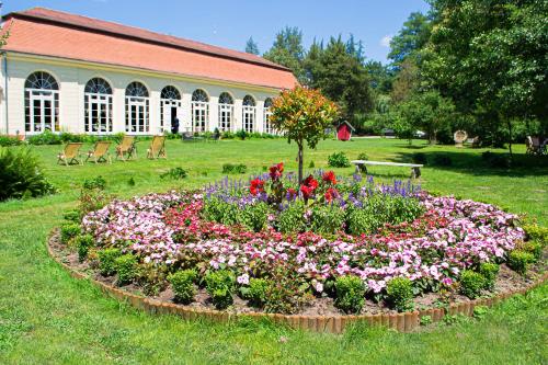 um jardim de flores na relva em frente a um edifício em Vila Hubertus em Avrig