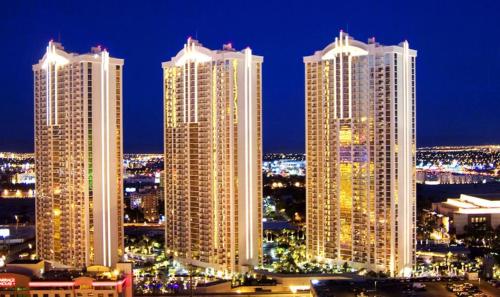 un groupe de grands bâtiments dans une ville la nuit dans l'établissement Jet Luxury Elite at The Signature, à Las Vegas