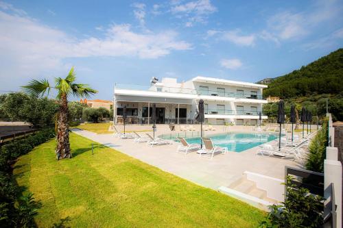 um grande edifício com uma piscina e um resort em The Angeliki Boutique Hotel em Skala Rachoniou