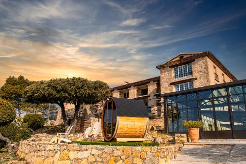 una casa con un objeto de madera delante de ella en La Bastide De Tourtour Hotel & Spa, en Tourtour