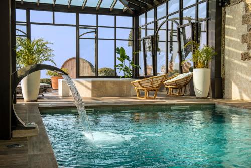 una piscina con una fuente de agua en una casa en La Bastide De Tourtour Hotel & Spa, en Tourtour