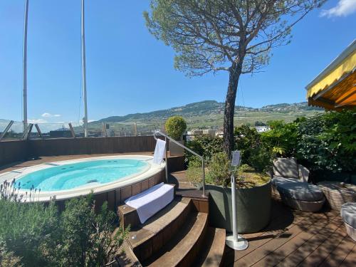 a hot tub in a backyard with stairs and a tree at Studios Astra Hotel Vevey in Vevey