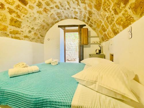 a bedroom with a bed with two towels on it at Vecchia Casa kamara in Monemvasia