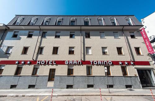 budynek hotelowy z czerwonym napisem w obiekcie Hotel Gran Torino w Turynie