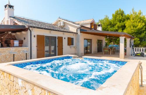 a hot tub in the backyard of a house at Villa Anabella in Supetar