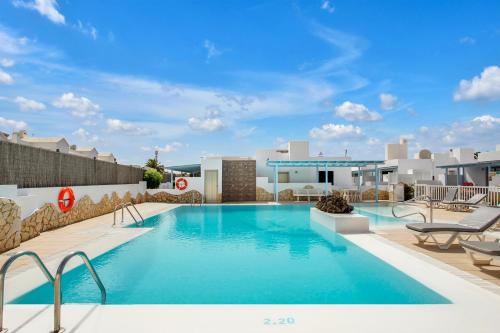 - une piscine d'eau bleue dans un complexe dans l'établissement Mar Azul Corralejo- Adults Only, à Corralejo