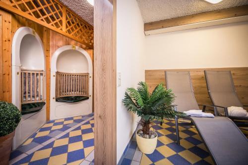 een kamer met stoelen en een tafel en een potplant bij AktiVital Hotel in Bad Griesbach