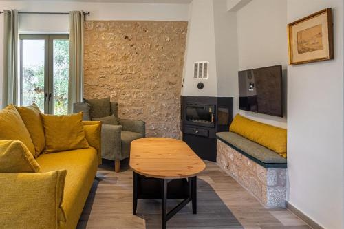 - un salon avec un canapé et une table dans l'établissement Mani Harmony Stone House, à Agios Nikolaos