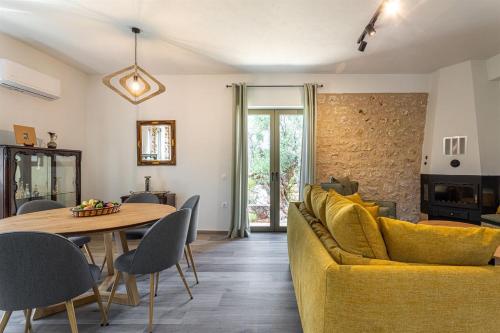 - un salon avec un canapé jaune et une table dans l'établissement Mani Harmony Stone House, à Agios Nikolaos