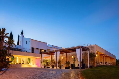 um edifício com uma fachada iluminada à noite em Vila Valverde Design Country Hotel na Praia da Luz